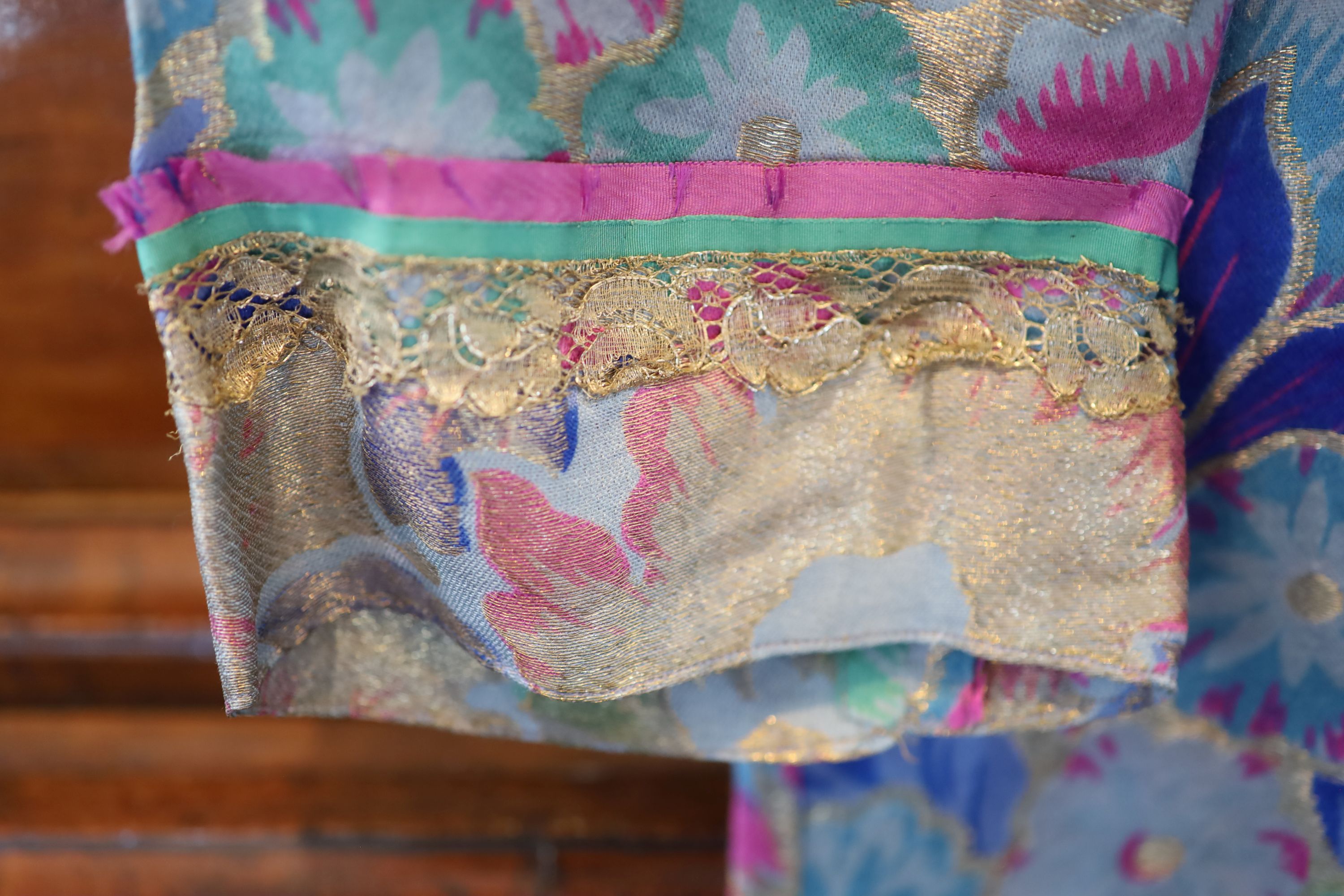 A 1940s silk lurex floral designed evening jacket, trimmed with gold coloured lace and a fine yellow wool skirt,